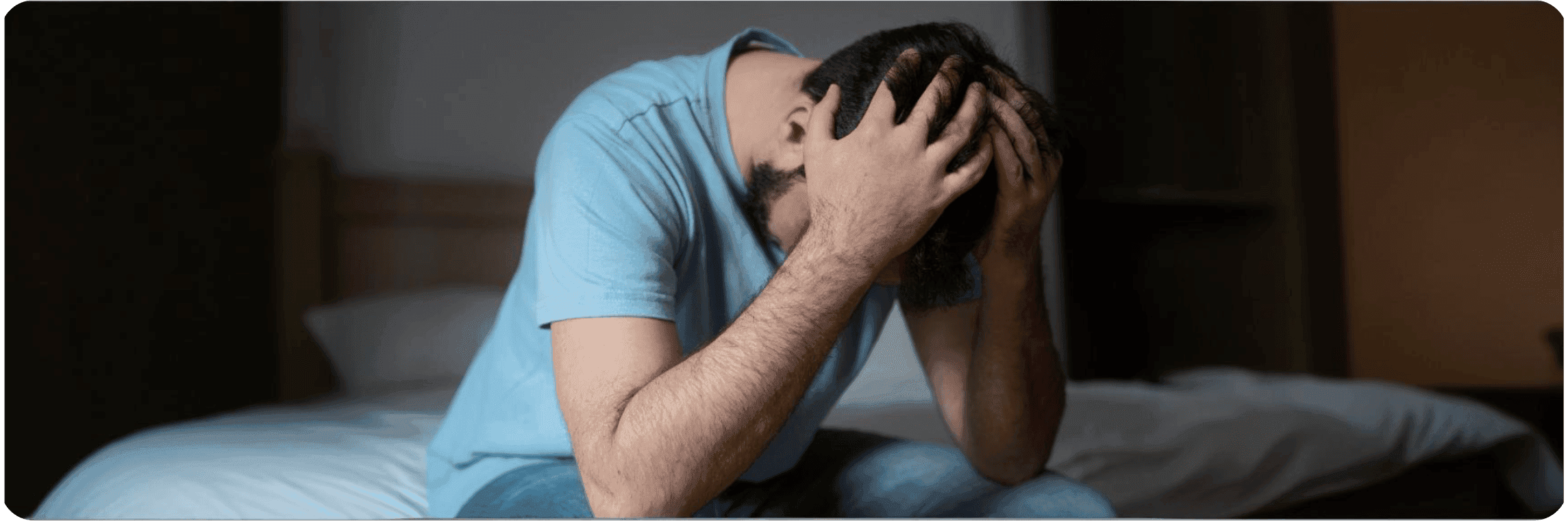 Muž  s úzkostně depresivní poruchou držící se za hlavu.