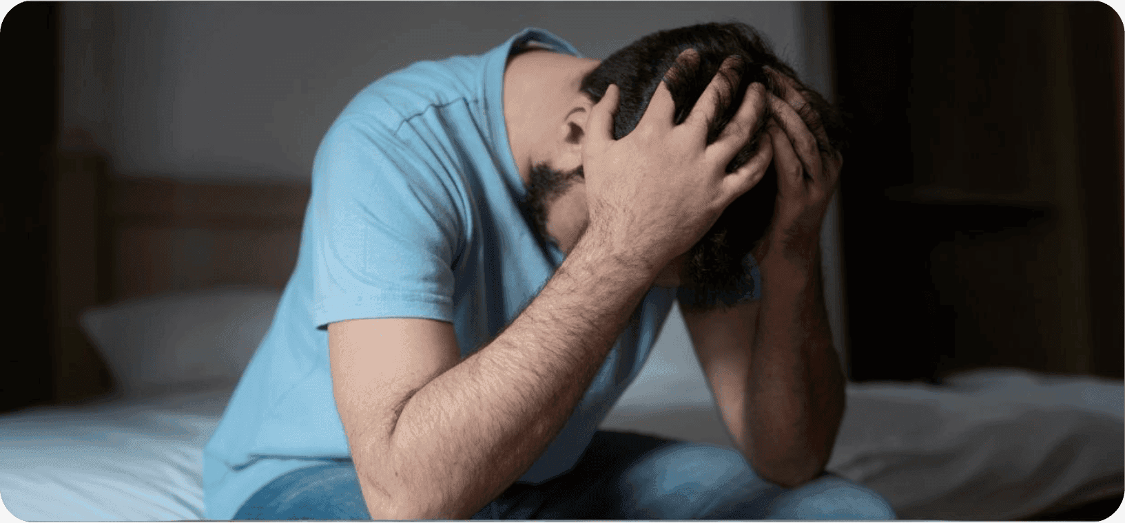 Muž  s úzkostně depresivní poruchou držící se za hlavu.