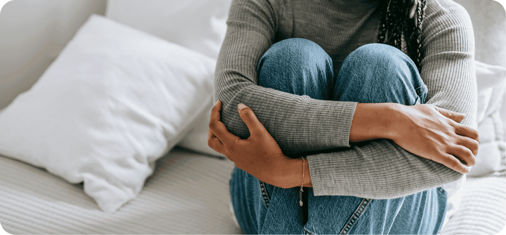 Úzkostná žena sedící na posteli.